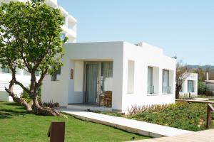 a white house with a tree in the yard at Can Salia in San Antonio Bay