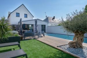 a backyard with a wooden deck and a swimming pool at Villa moderne avec piscine pour 15 personnes ! in Saint-Gildas-de-Rhuys