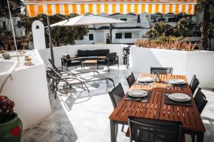 an outdoor patio with a wooden table and chairs at Anais Marbella in Marbella