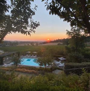 Blick auf einen Pool mit Sonnenuntergang im Hintergrund in der Unterkunft Villa Mercatello Umbria in Mercatello