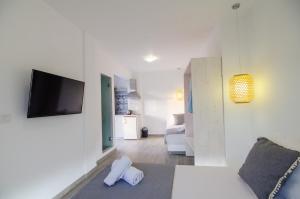 a white room with a television and a living room at Maria's View Delux in Ios Chora