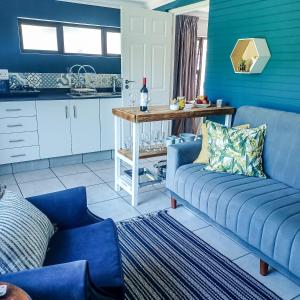 a living room with blue walls and a blue couch at Big Blue Breaks in Umkomaas