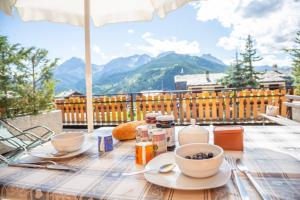 a table with food and drinks on top of a balcony at Appartamenti & Wellness Piero Gros in Sauze dʼOulx