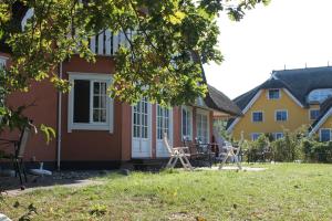 アーレンスホープにあるHaus Strandgutの庭の椅子とテーブル付き家