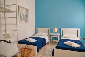 - 2 lits dans une chambre bleue et blanche avec miroir dans l'établissement Casa Levante, à Monopoli
