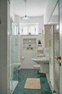Un baño con lavabo, inodoro y ducha. en Casa Levante, en Monopoli 32 fotos más