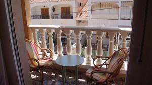- Balcón con 2 sillas, mesa y valla en Mar Menor apartments, en San Pedro del Pinatar