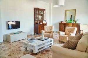 Una sala de estar con un sofá y sillas y un televisor. en Casa Levante, en Monopoli
