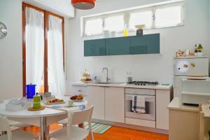cocina blanca con mesa, mesa y sillas en Casa Levante, en Monopoli