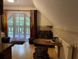 a living room with a table and a large window at Willa Górska in Karpacz