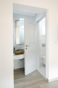 a bathroom with a white door and a sink at Maria's View Delux in Ios Chora