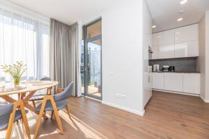 a kitchen and dining room with a table and chairs at Sunset Apartment at Sventosios Vartai in Palanga