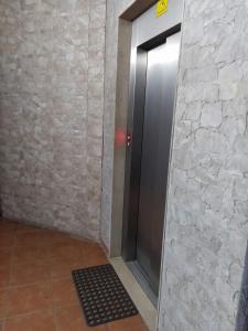a elevator in a room with a stone wall at Jozi Kaiser Apartment 2 in Durrës
