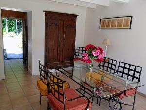 uma sala de jantar com uma mesa de vidro e cadeiras em Cottage sur le Domaine du golf de la Bretesche em Missillac