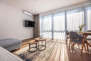 a living room with a couch and a table at Sunset Apartment at Sventosios Vartai in Palanga
