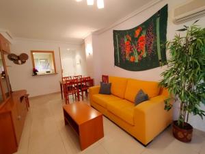 a living room with a yellow couch and a table at ACV - Vistamar II-1ª linea planta 3 sur in Oropesa del Mar