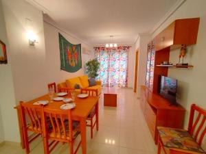 uma sala de jantar e sala de estar com uma mesa de madeira em ACV - Vistamar II-1ª linea planta 3 sur em Oropesa del Mar