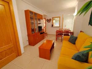 uma sala de estar com um sofá amarelo e uma mesa em ACV - Vistamar II-1ª linea planta 3 sur em Oropesa del Mar
