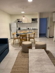 eine Küche mit einem Tisch und eine Küche mit einem Kühlschrank in der Unterkunft Departamentos boutique in La Falda