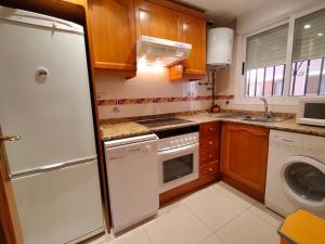 a kitchen with a white refrigerator and a dishwasher at ACV - Vistamar II-1ª linea planta 3 sur in Oropesa del Mar