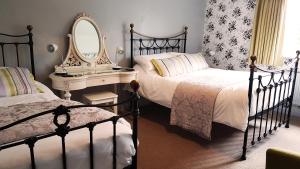 een slaapkamer met 2 bedden, een spiegel en een dressoir bij The Royal Oak Duddington in Stamford