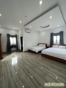 duża sypialnia z 2 łóżkami i drewnianą podłogą w obiekcie Chiến Cảnh Hotel w mieście An Châu