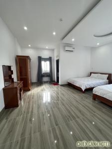 a bedroom with two beds and a desk in it at Chiến Cảnh Hotel in An Châu