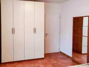 um quarto com armários brancos e um armário em Comodo appartamento [Trento centro] Il Duomo Bianco em Trento