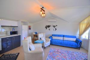 - un salon avec un canapé bleu et deux chaises dans l'établissement Fethiye Sea View Suites, à Fethiye