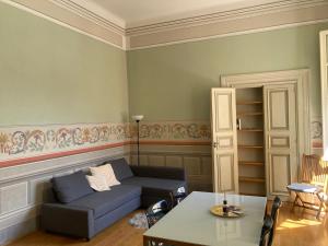 a living room with a couch and a table at Puccini's Home, elegant apartment in Piazza Puccini in Lucca