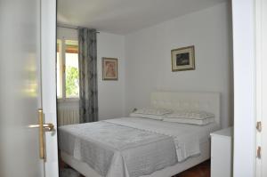 - une chambre blanche avec un lit et une fenêtre dans l'établissement Apartmaji Štamcar, à Izola