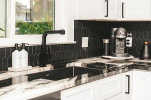 una cocina en blanco y negro con fregadero en Historic Waterfront 3/2 With Yard & Modern Kitchen en Lake Worth