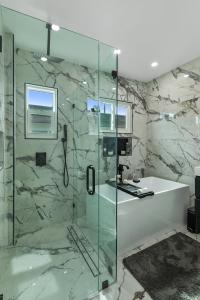 y baño con ducha de cristal y bañera. en Historic Waterfront 3/2 With Yard & Modern Kitchen en Lake Worth