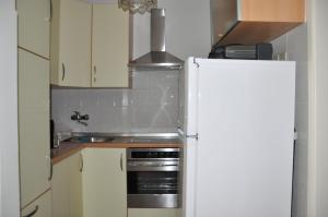 a kitchen with a white refrigerator and a sink at Apartmaji Štamcar in Izola