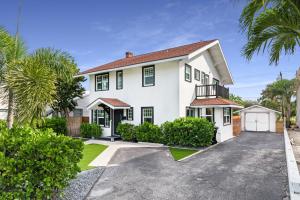 a white house with black windows and a driveway at Historic Waterfront estate With Yard & Modern Kitchen in Lake Worth