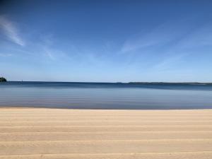 una playa de arena con el océano en el fondo en Newly built attefallshus by the beautiful Varamobeach!, en Motala