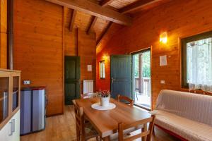 a dining room with a table and a couch at Villaggio Anemone Chalet Scoiattolo in Capanne di Sillano