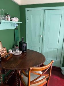 a wooden table with two chairs in a room with green walls at B&B Suupmarkt in Dokkum