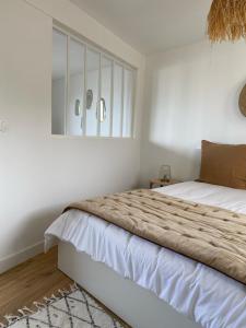 sypialnia z 2 łóżkami i oknem w obiekcie Casa Nomad - appartement cozy les pieds dans l'eau w mieście Ploemeur