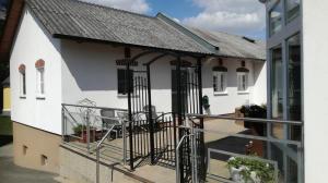 a white house with a balcony and a building at S´ Kellerstoeckl in Fehring