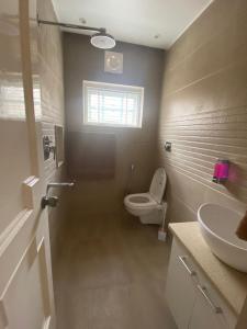a bathroom with a toilet and a sink at BELLE VUE COTTAGES in Kūd