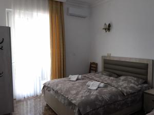 a bedroom with a bed and a large window at Rezo's House in Kvariati