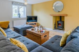 a living room with two couches and a wood stove at Orchard Cottage in Alderton