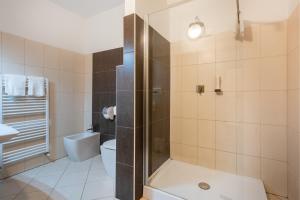 y baño con ducha, aseo y lavamanos. en Hotel De Nac, en Nago-Torbole