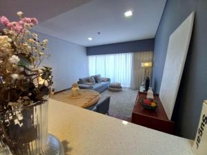 uma sala de estar com um sofá e um vaso de flores em Cabedelo Beach Apartment em Viana do Castelo