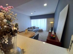 a living room with a couch and a vase of flowers at Cabedelo Beach Apartment in Viana do Castelo