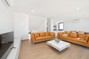 a living room with two orange couches and a table at Casa do Sol - By SCH in Salir de Porto