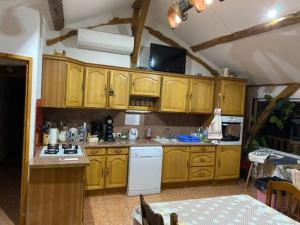 een keuken met houten kasten en een witte koelkast bij GITE A LA FERME in Montesquieu-Avantès