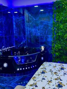 拿坡里的住宿－多莫斯2號旅館，浴室设有黑色浴缸和蓝色瓷砖墙。