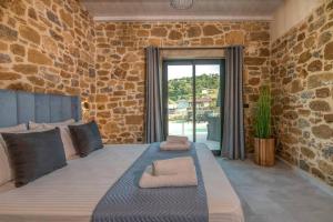 Un dormitorio con una cama grande con una pared de piedra. en White House Boutique, en Koukounará 34 fotos más